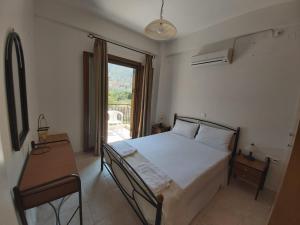 a bedroom with a bed and a table and a window at Domaine Papakonstantis in Skoutari