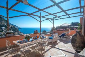 a patio with a table and chairs and the ocean at Casa della Nonna in Positano
