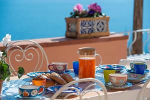 a table with plates of food and a pitcher of juice at Casa della Nonna in Positano