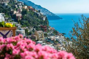 a view of a town on a hill with pink flowers at Casa della Nonna in Positano