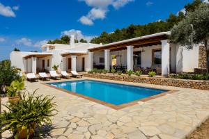 une villa avec une piscine en face d'une maison dans l'établissement Can Palau, à Sant Joan de Labritja
