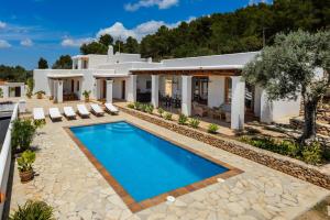 a villa with a swimming pool in front of a house at Can Palau in Sant Joan de Labritja