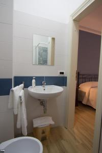 ein Bad mit einem Waschbecken und einem Spiegel in der Unterkunft Relax da Carmen in Vatolla