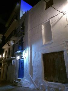 un edificio blanco con una puerta azul por la noche en Casa El Grial, en Peñíscola