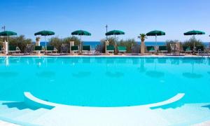 a large swimming pool with chairs and umbrellas at Residence Chiesiola in Vieste