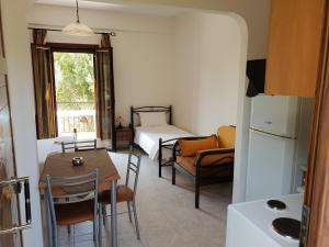 a room with a table and a bed and a kitchen at Domaine Papakonstantis in Skoutari