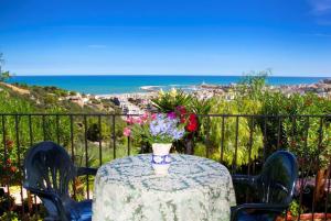 a table with a vase of flowers on top of it at Residence Chiesiola in Vieste
