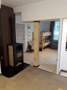 a living room with a wood stove and a bedroom at Sun Boat Apartments in Ventspils