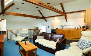 uma sala de estar com um sofá e duas cadeiras e uma mesa em Dale Farm Holidays em Hunmanby