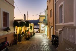 een steegje in een stad met tafels en stoelen bij Pier Apartments in Karpathos