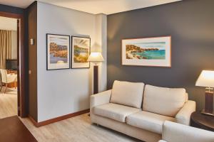 a living room with a couch and paintings on the wall at Silken Coliseum in Santander