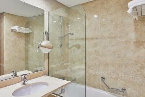 a bathroom with a sink and a glass shower at Silken Coliseum in Santander