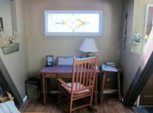 Cette chambre comprend une table avec une chaise et une fenêtre. dans l'établissement Always Inn Idyllwild Vacation Cottages, à Idyllwild