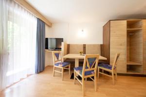 a dining room with a table and chairs and a television at Appartements Waldesrand in Sölden