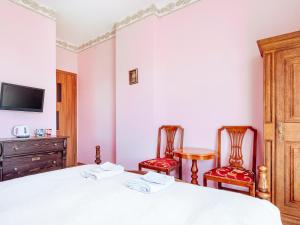 - une chambre avec un lit et deux chaises dans l'établissement Villa Nicolo, à Władysławowo