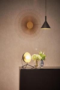 a lamp and flowers on a table with a mirror at Silken Coliseum in Santander