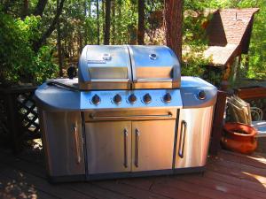 un poêle bleu et argenté sur une terrasse dans l'établissement Always Inn Idyllwild Vacation Cottages, à Idyllwild