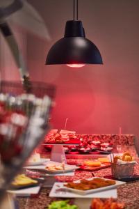 a buffet with plates of food and a red wall at Silken Coliseum in Santander