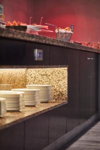 a counter with white plates on a shelf at Silken Coliseum in Santander