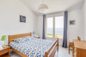 - une chambre avec un lit et une fenêtre donnant sur l'océan dans l'établissement EL ORO - Terrasse Vue Mer et piscine - Porto Vecchio, à Porto-Vecchio
