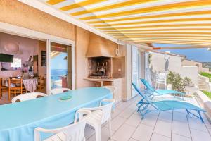 d'une terrasse avec une table bleue et des chaises blanches. dans l'établissement EL ORO - Terrasse Vue Mer et piscine - Porto Vecchio, à Porto-Vecchio