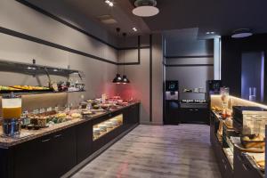 a kitchen with a buffet line with food on display at Silken Coliseum in Santander