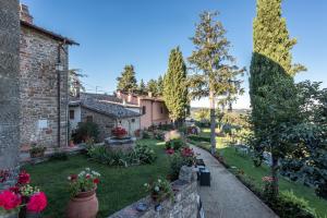 a garden of a house with flowers and trees at Castellinuzza in Greve in Chianti