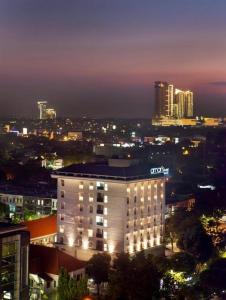 a lit up building in a city at night at Amaris Hotel Darmo Surabaya in Surabaya
