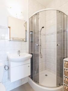 a white bathroom with a shower and a sink at Villa Nicolo in Władysławowo