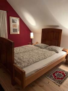 a large bed in a bedroom with a red wall at Holiday Home Luka 10 in Kalnik