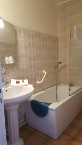 a bathroom with a sink and a bath tub and a sink at Hotel Raymond VII in Cordes-sur-Ciel