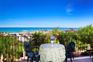 a table with chairs and a vase of flowers on a balcony at Residence Chiesiola in Vieste