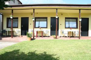 a patio with tables and chairs in a yard at OPTY - Pokoje Gościnne in Łeba