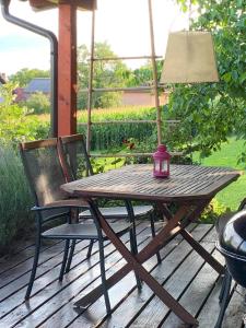 a wooden table with a lamp and chairs on a deck at Holiday Home Luka 10 in Kalnik