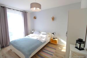 sypialnia z łóżkiem i dużym oknem w obiekcie Apartament Włochatka z sauną fińską w Świeradowie Zdroju