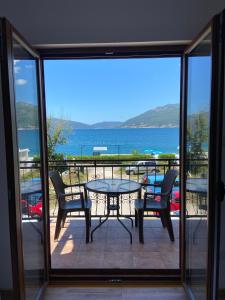 einen Balkon mit einem Tisch und Stühlen sowie Meerblick in der Unterkunft Apartments Family in Tivat