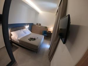 una piccola camera con letto e televisore di 11 Catalani Rooms a Porto Cesareo