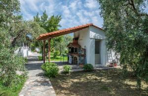 una pequeña casa con un horno al aire libre en un patio en Pension Karadolas Rachoni, en Skala Rachoniou