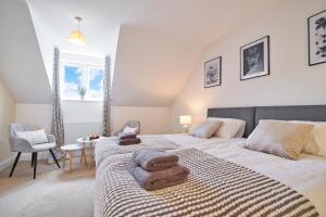 um quarto com 2 camas e toalhas em MODERN and SPACIOUS HOUSE CLOSE TO THE CITY CENTRE em Peterborough