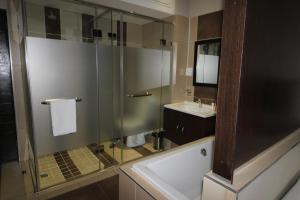 a bathroom with a glass shower and a sink at Alcazaba Lodges in Johannesburg