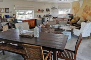 a large living room with a wooden table and chairs at Staples House - Living The Breede in Malgas