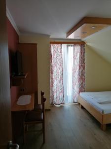 a small room with a bed and a window at Kirchenwirt Mirth in Eltendorf