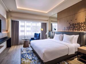 Mercure Jakarta Batavia في جاكرتا: غرفه فندقيه سرير كبير وتلفزيون