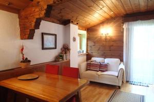 a living room with a table and a chair at Gästehaus Rosa Leitgeb in Faistenau