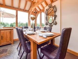 a dining room with a wooden table and chairs at Hyde Tyning Cottage in Minchinhampton