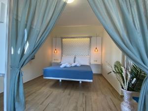 Schlafzimmer mit blauem Bett und blauen Vorhängen in der Unterkunft Michail Suites Afiartis Karpathos in Karpathos