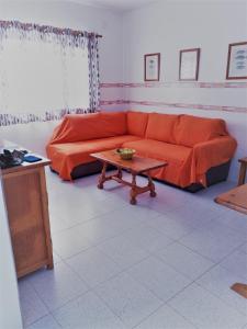 Sala de estar con sofá rojo y mesa de centro en Apartamentos herederos Lm, en Caleta de Sebo