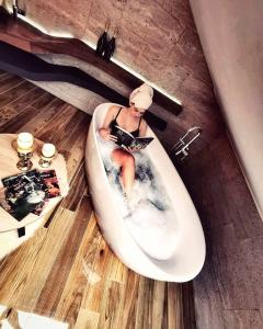 a woman sitting in a bath tub reading a magazine at La Vela Luxury in Trogir