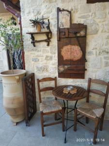 a wooden table and two chairs and a table and a pot at Amazing Stone Villas in Kapetanianá +33 photos