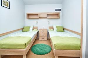 Senta的住宿－Ana Guesthouse，客房设有两张单人床和一个床头柜。